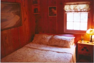 Bedroom in the cottage. Knotty pine walls, Tiffany lamps - cabins on the river in the forest at Gathering Light ... a retreat for nature lovers, a retreat for writers and artists, for lovers and honeymooners and a peaceful, personal spiritual retreat. Offering private, studio cabins, treehouses, vacation rentals, group and family lodging, the retreat is located in southern oregon near crater lake national park.